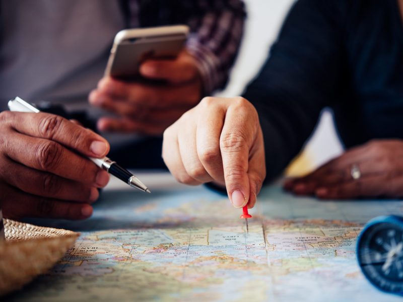 Travelers are planning a trip by searching the route on the map and searching for information on the internet.